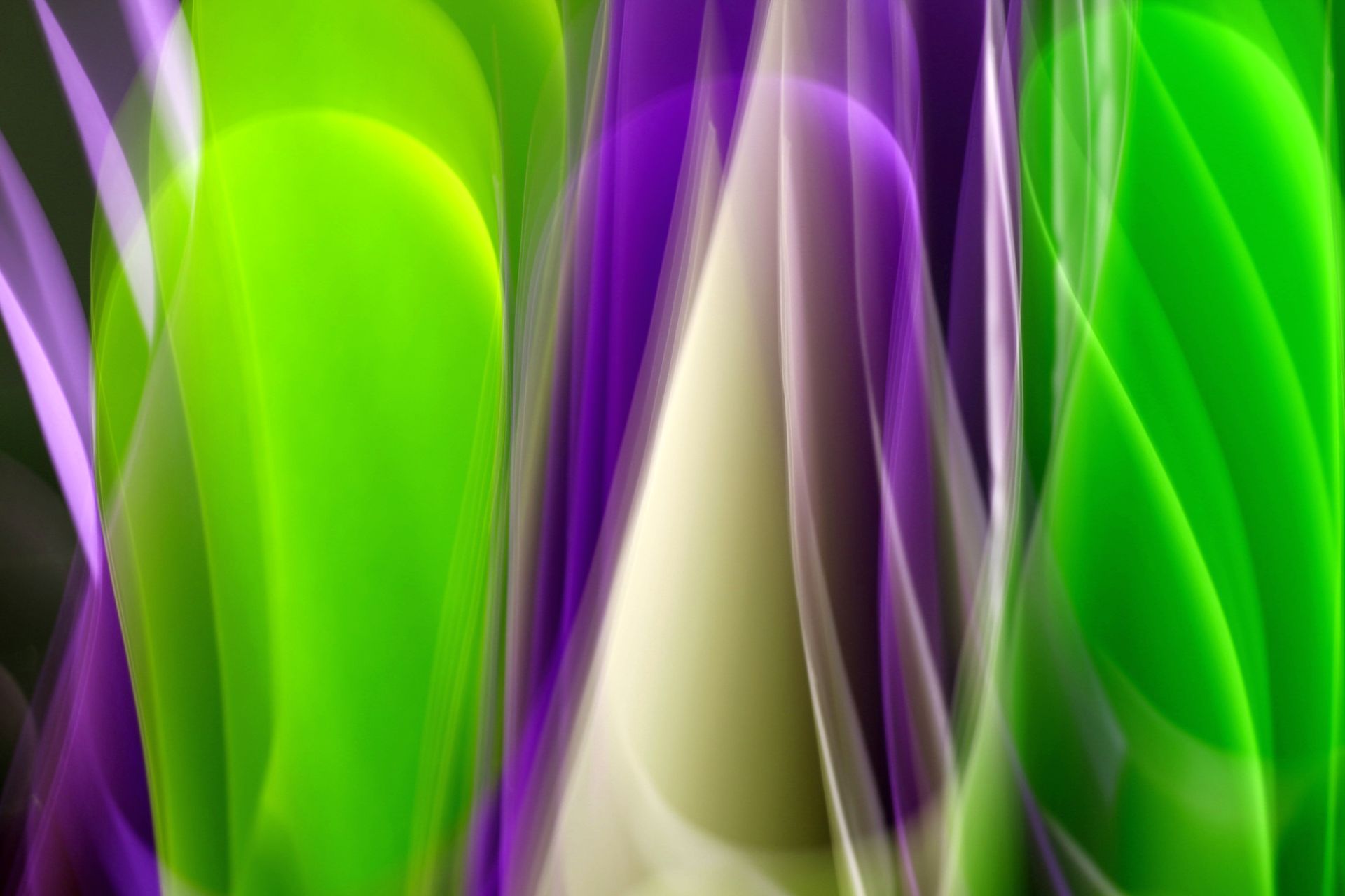 Vibrant abstract image with dynamic green and purple light streaks on a dark background.