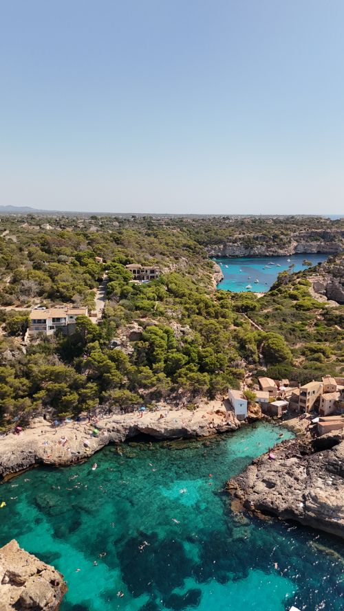 Free Aerial shot of Mallorca's stunning coastline with crystal clear waters and lush greenery. Stock Photo