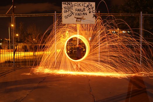 Vibrant steel wool light painting capturing luminous sparks in a night setting.