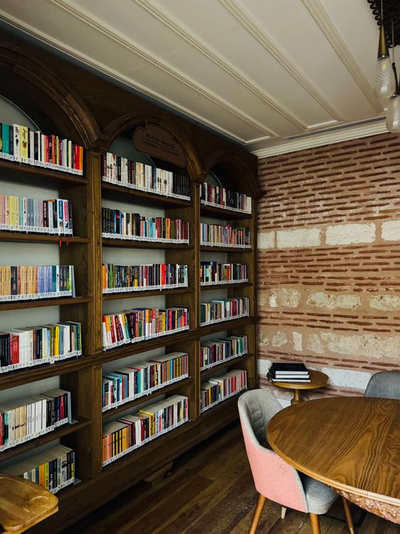 Cozy Library Corner with Bookshelves and Table ยท Free Stock Photo
