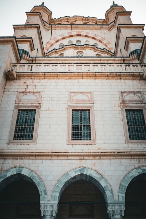 Free Close-up of a historic building facade featuring arched windows and ornate architectural details. Stock Photo