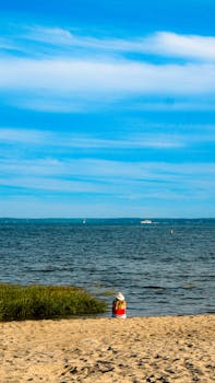 Relaxing view of a lone person at a sandy beach in Connecticut, USA on a sunny summer day.