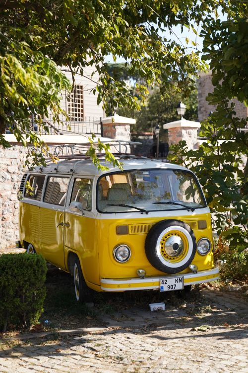 Free A classic yellow Volkswagen van parked under trees in a charming Istanbul setting. Stock Photo