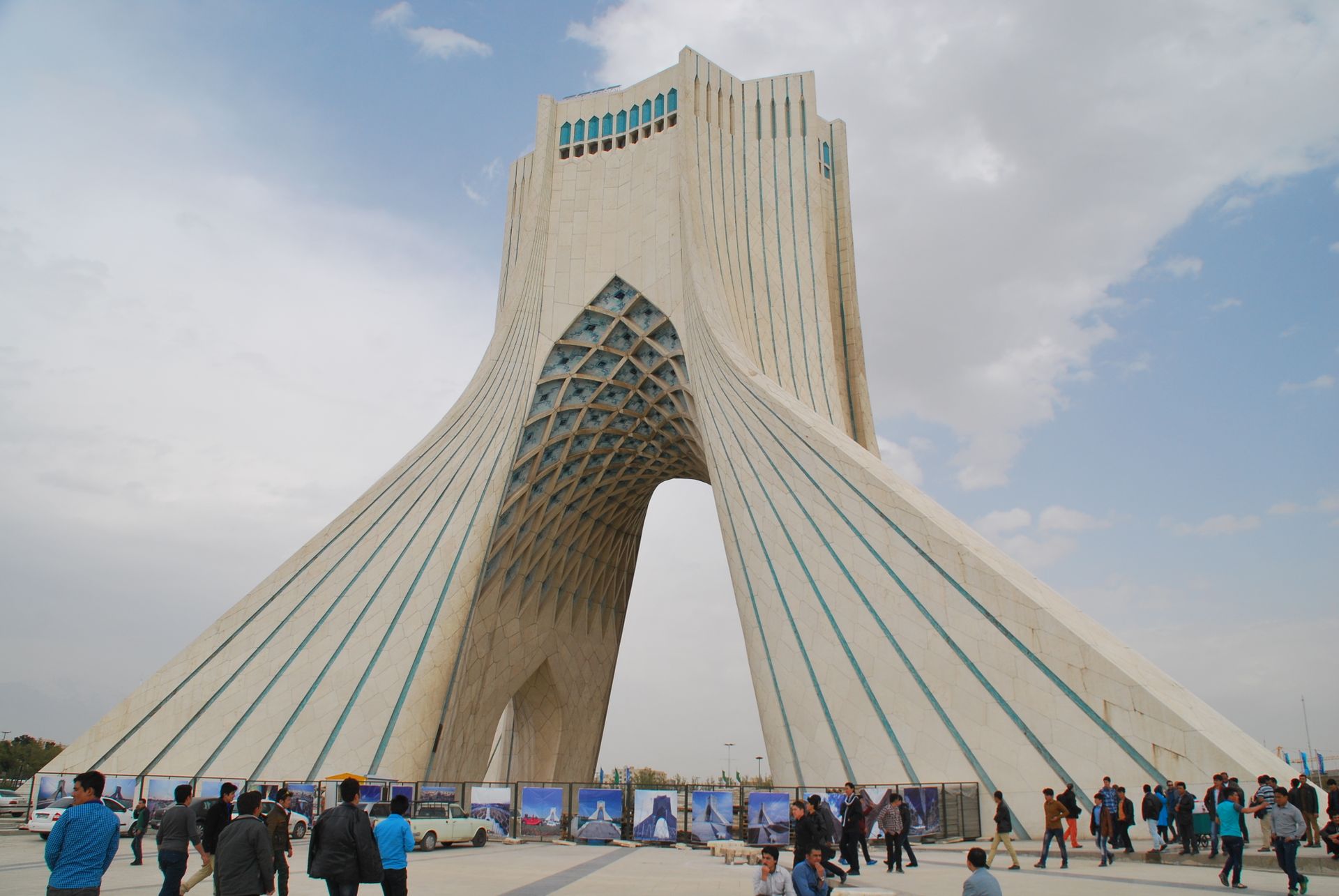 View of the iconic Azadi Tower in Tehran, Iran with visitors in the foreground on a clear day.