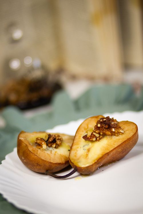 Free Delicious baked pear topped with walnuts and honey, elegantly presented on a plate. Stock Photo