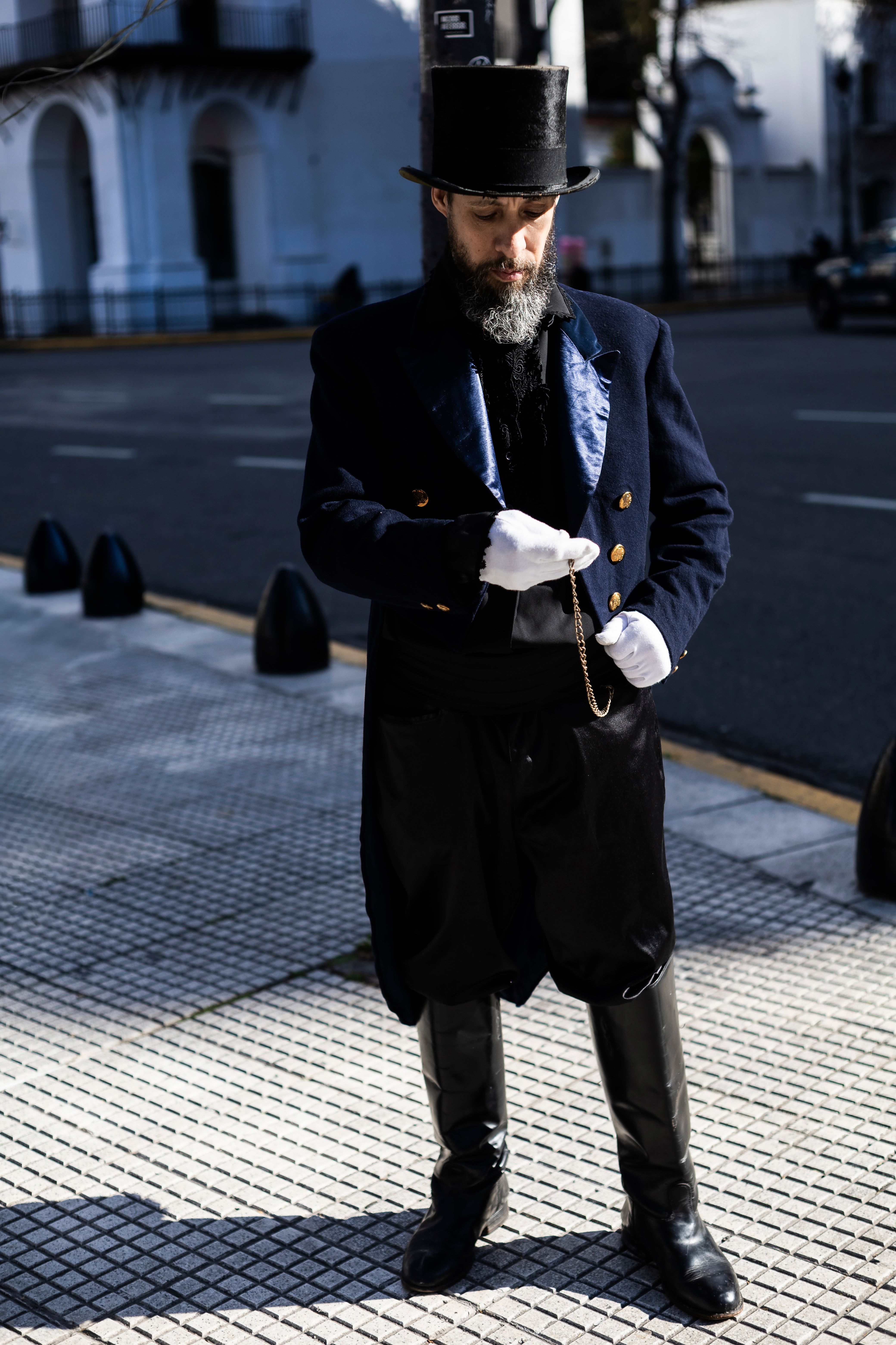 A man dressed in Victorian attire stands on a sidewalk in Buenos Aires, Argentina.