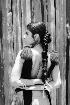 Stylish black and white portrait of woman in traditional attire with intricate braided hairstyle.