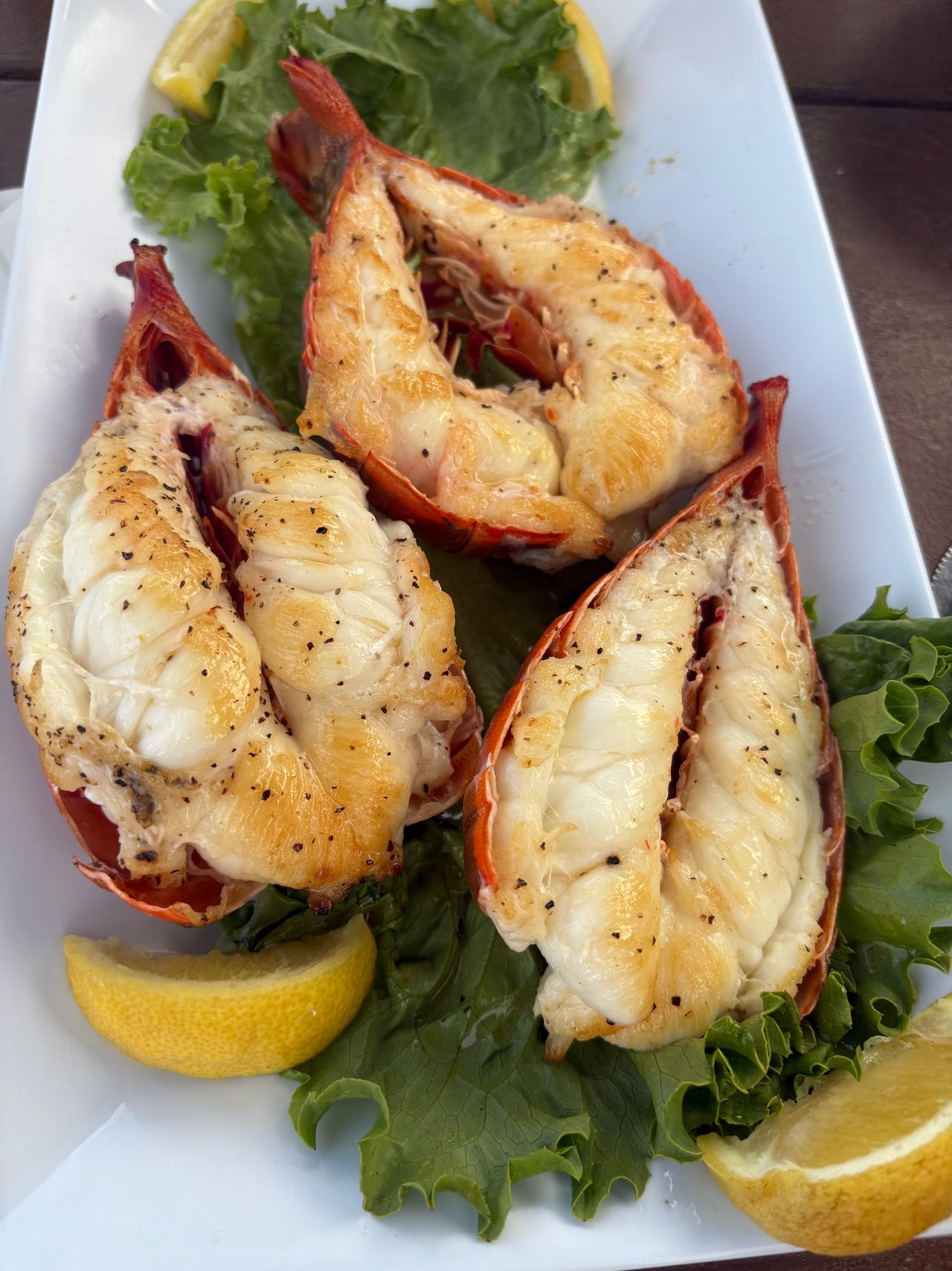 Grilled lobster tails on a bed of greens