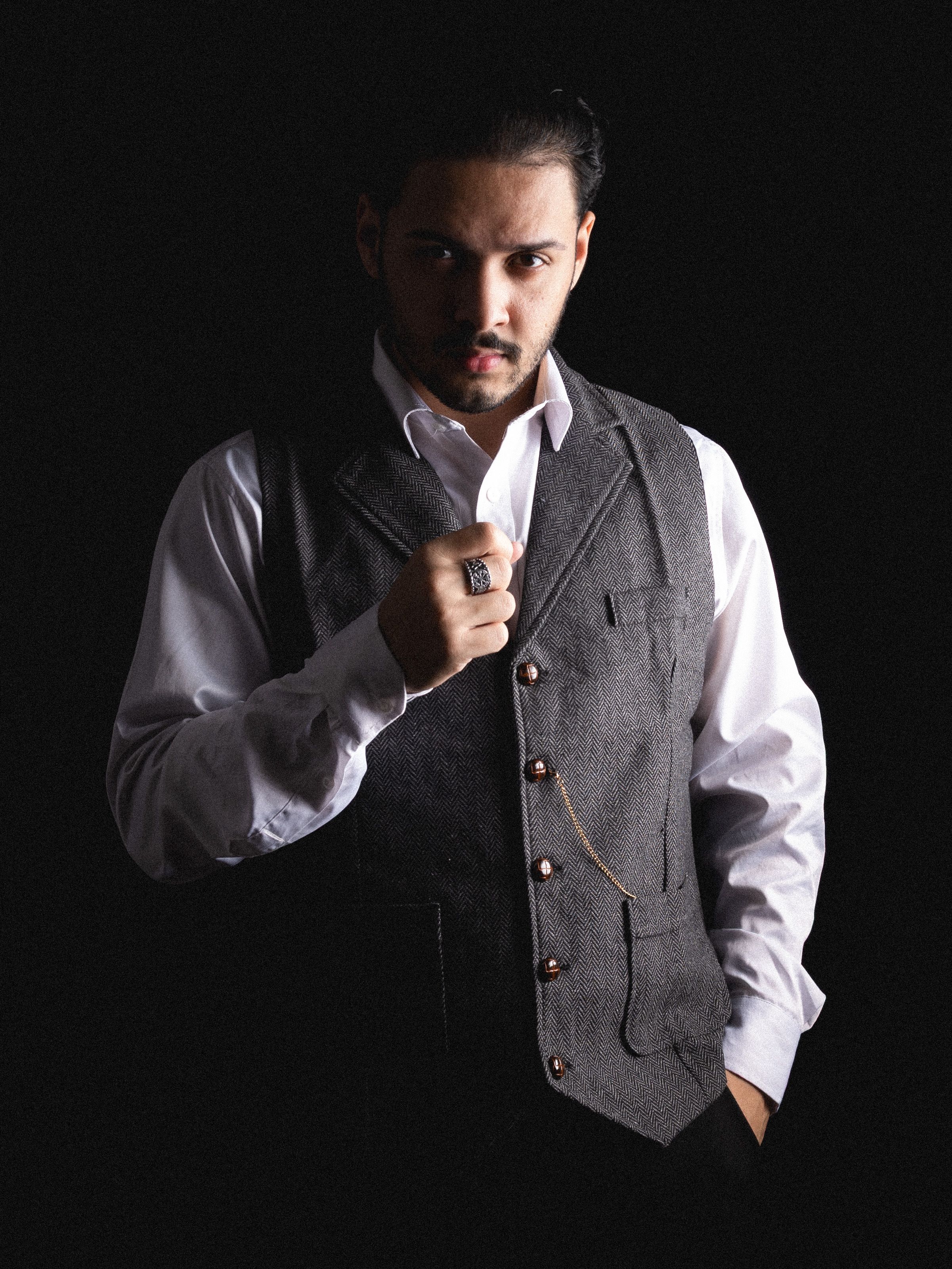 Sophisticated portrait of a man in a vintage suit against a dark background.