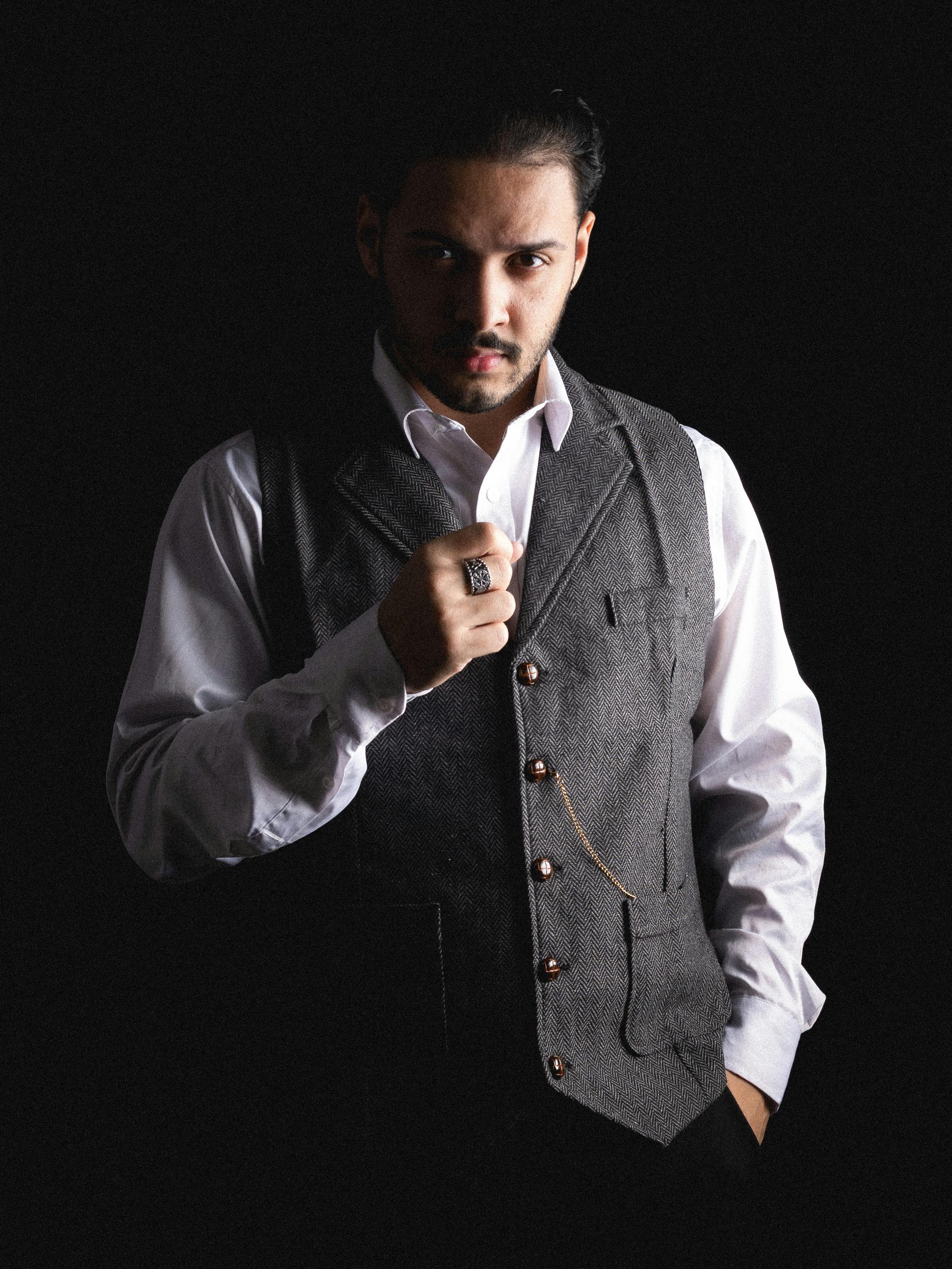 Gratis Potret canggih seorang pria mengenakan setelan vintage dengan latar belakang gelap. Foto Stok