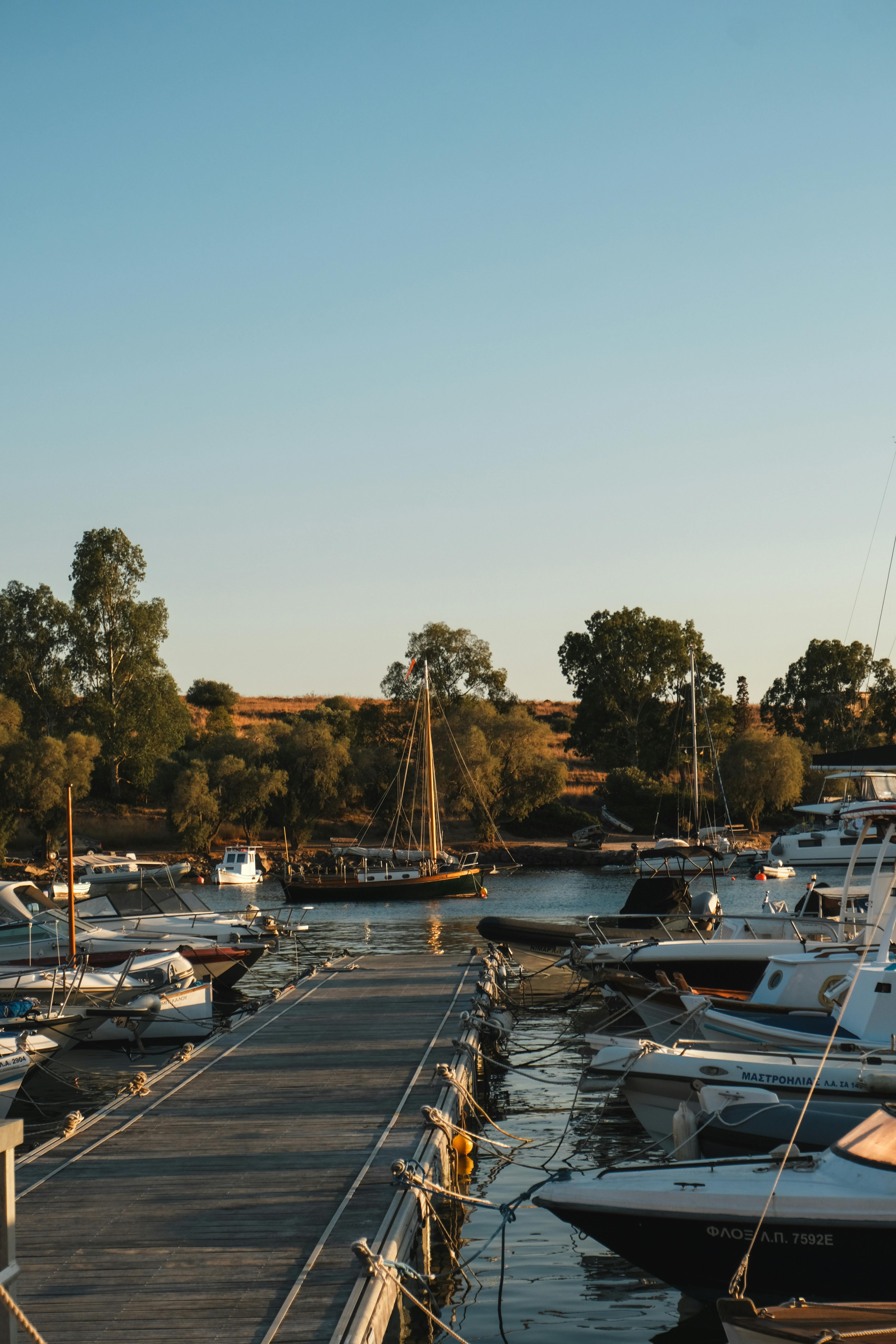 Serene marina with boats docked at sunset, showcasing a peaceful island atmosphere.