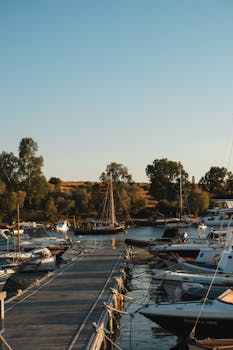 Serene marina with boats docked at sunset, showcasing a peaceful island atmosphere.