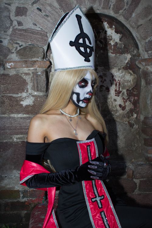 Free A person in a Gothic costume and face paint poses in an ancient stone setting. Stock Photo