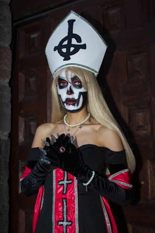 Free A woman dressed in a skeleton makeup and religious-themed costume, standing indoors. Stock Photo