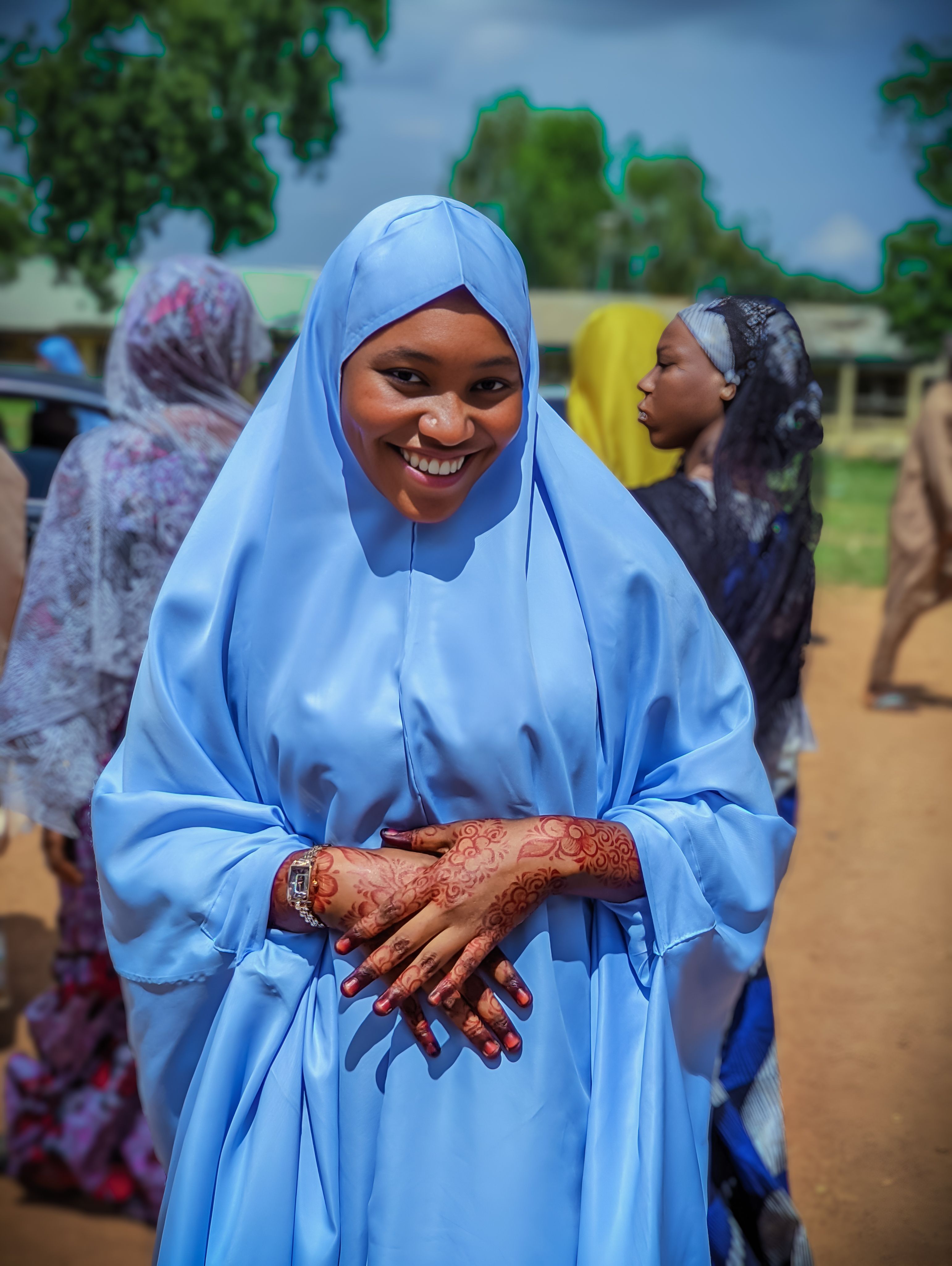 Smiling Woman in Traditional Blue Attire Outdoors · Free Stock Photo
