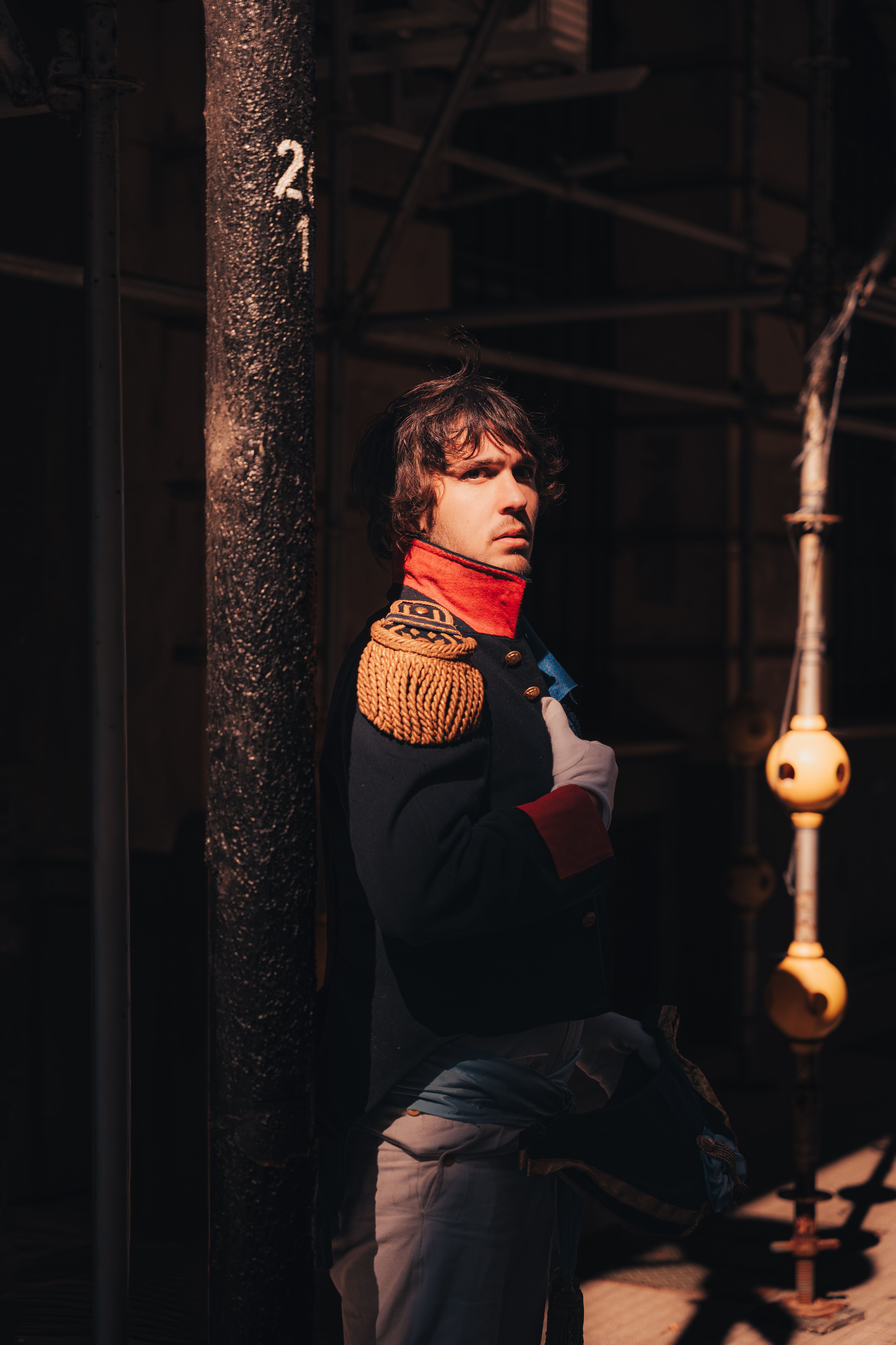 Historical reenactment of a soldier in vintage uniform with dramatic lighting.