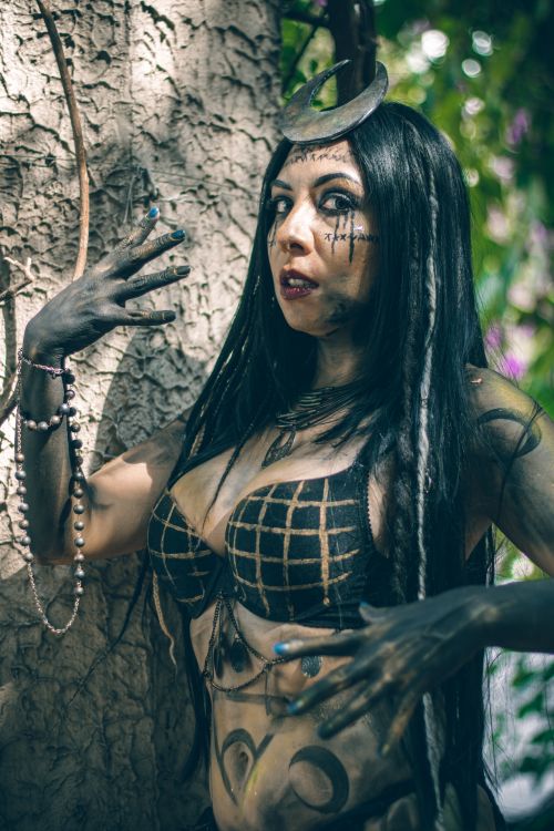 Free A woman with creative makeup posing dramatically in a park setting. Stock Photo