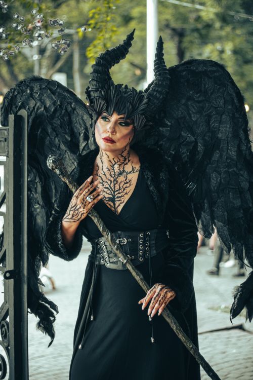 Free Person in dark fantasy costume with horns and wings in a city park setting. Stock Photo