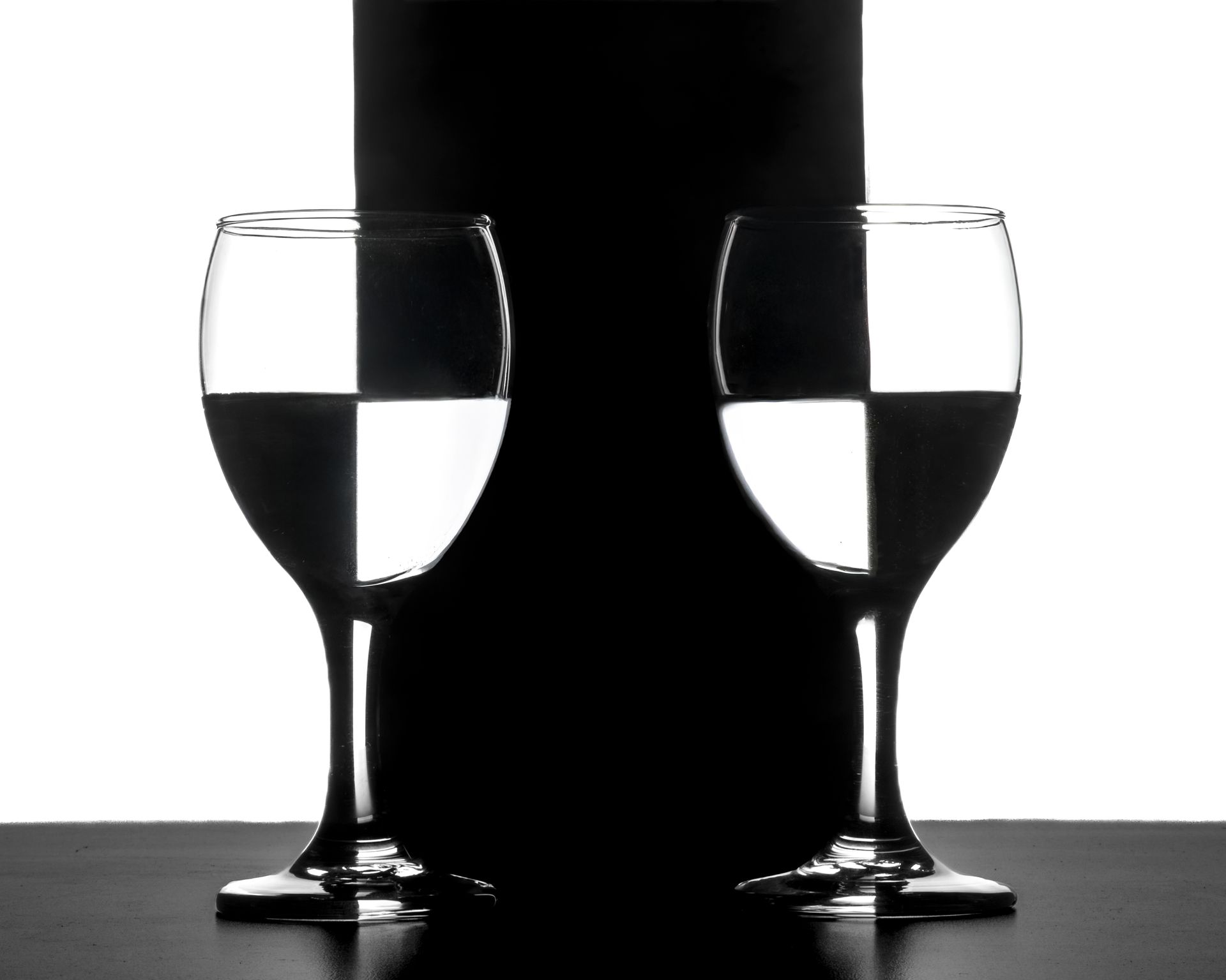 Two glasses create a striking geometric pattern through a play on black and white contrast.