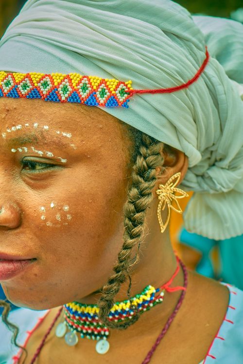 Free A close-up of a Nigerian woman in traditional attire with intricate beadwork and facial paint. Stock Photo