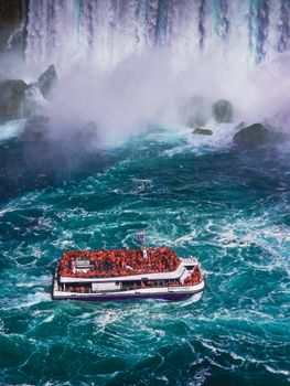 A tour boat braves the turbulent waters near Niagara Falls, offering a thrilling adventure experience.