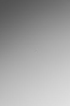 A small airplane captured in a minimalist scene with a clear blue sky, conveying a sense of freedom.