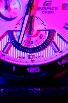 Macro shot of analog watch face with vibrant neon lighting and precision details.