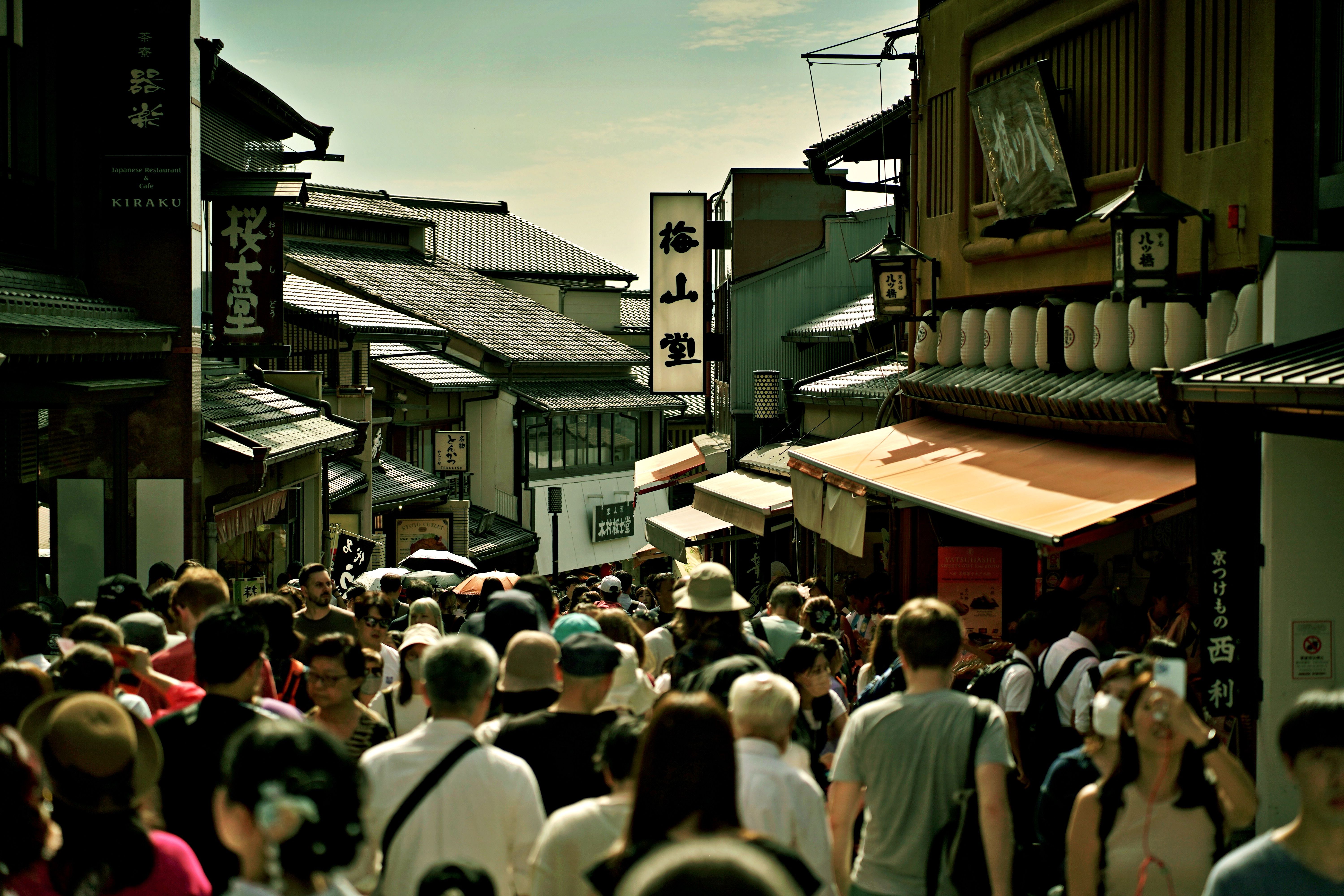 Busy pedestrian street in Kyoto, Japan, showcasing traditional architecture and vibrant life.