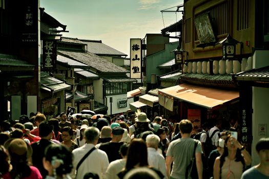Busy pedestrian street in Kyoto, Japan, showcasing traditional architecture and vibrant life.