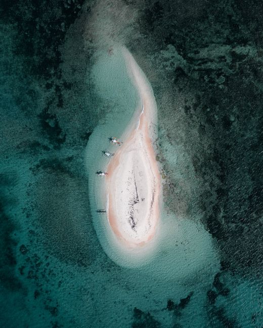 Stunning aerial capture of a secluded island surrounded by turquoise waters in the Philippines.