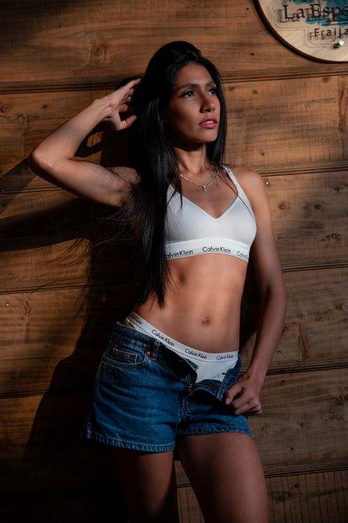 Free Young woman posing indoors in casual fitness wear, showcasing confidence. Stock Photo
