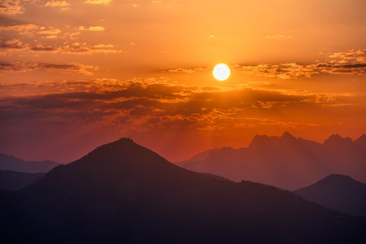 A picturesque sunset view over silhouetted mountains and vibrant skies.
