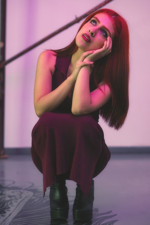 Free A young woman in deep thought under artistic, vibrant lighting in CDMX, Mexico. Stock Photo