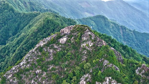 A stunning aerial view of lush green mountains and rocky ridges.