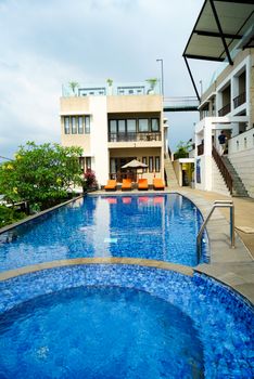 Elegant hotel exterior with a stunning poolside view and modern architecture, perfect for relaxation.