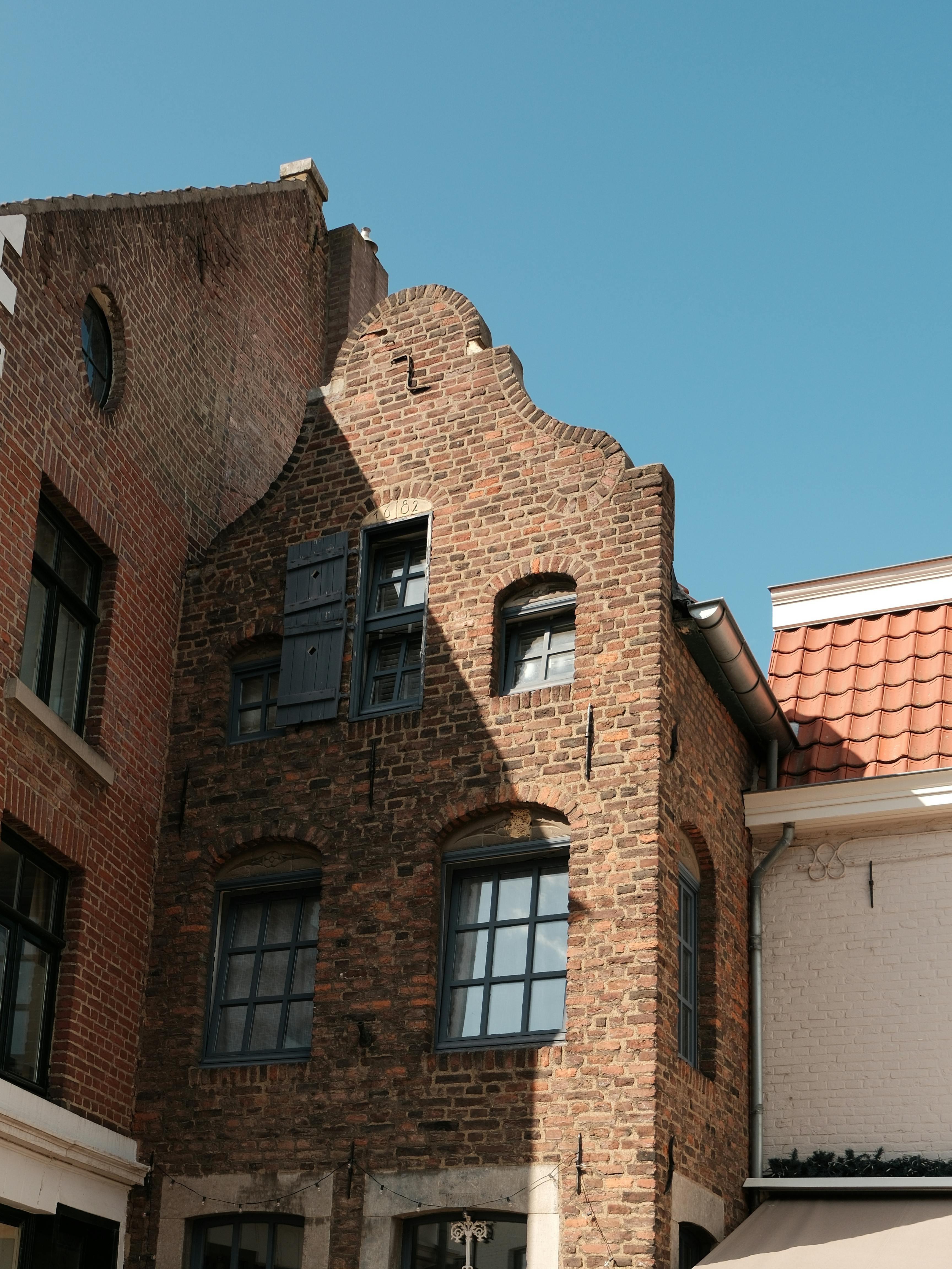 A charming historic European brick building with arched windows and traditional architecture under a clear blue sky.
