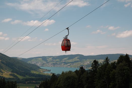 Red gondola gliding over Swiss lake with lush mountains in the background, showcasing breathtaking scenery.