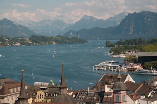 A stunning view of Lake Lucerne, mountains, and the city skyline on a bright day.