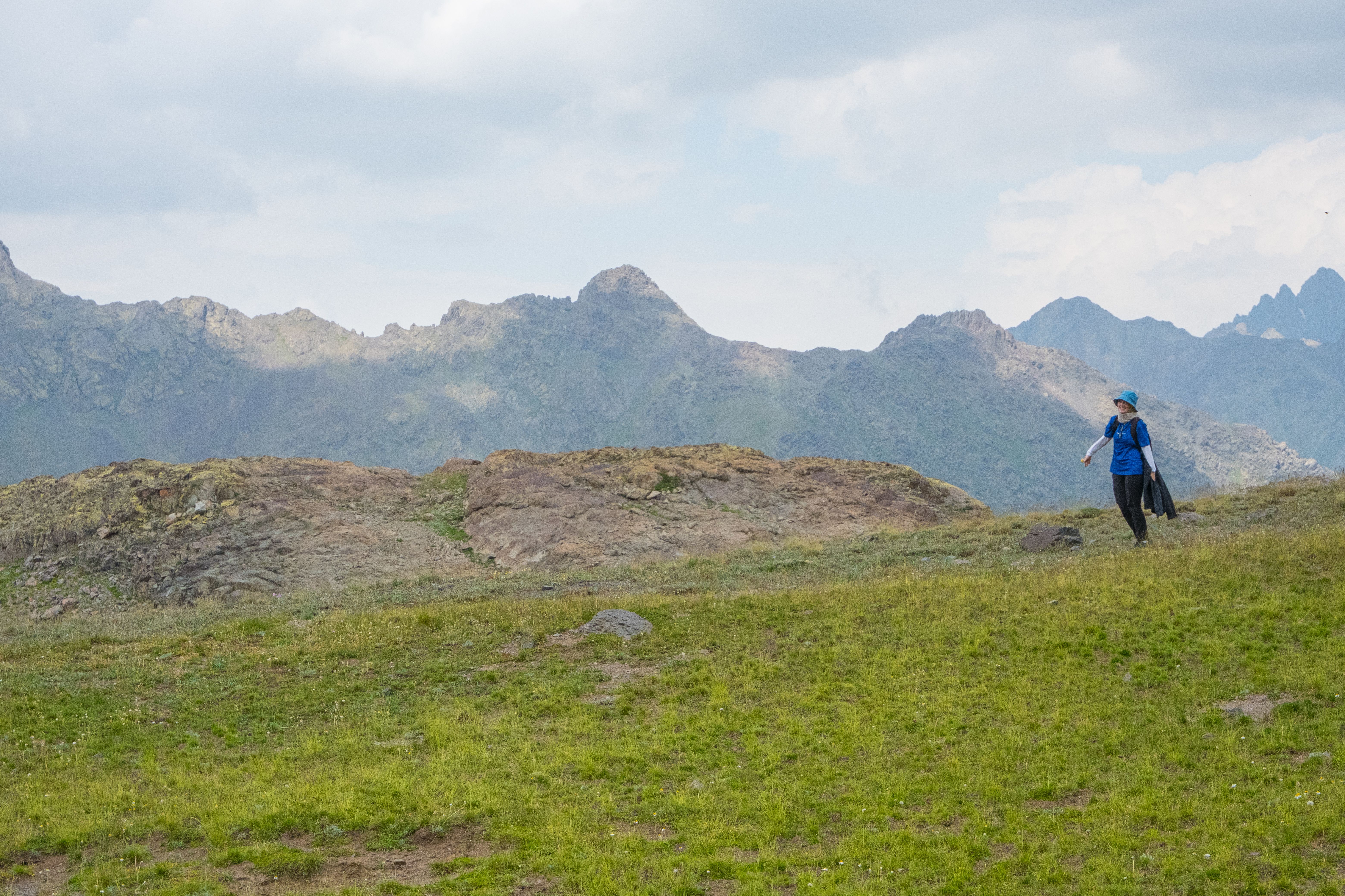 A lone hiker on an alpine trail, the path ahead clearly marked