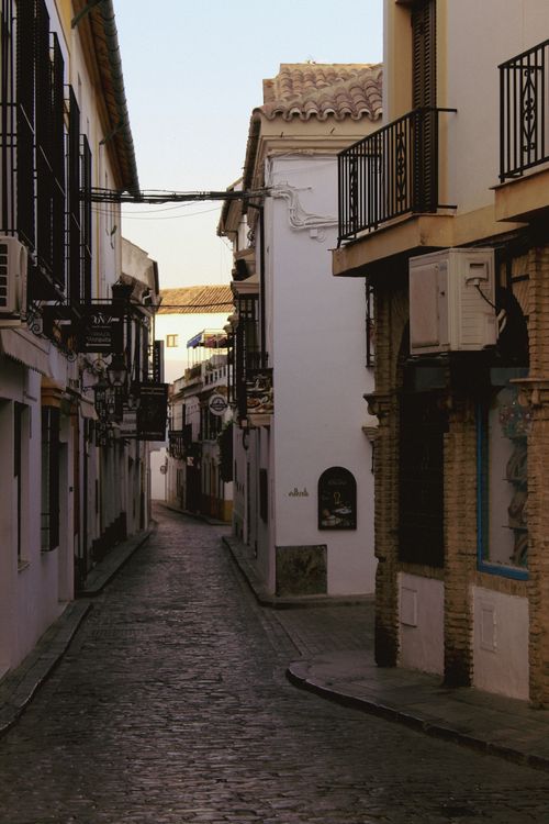 Free Explore the serene and picturesque narrow streets of Córdoba during sunset, capturing historical Spanish architecture. Stock Photo