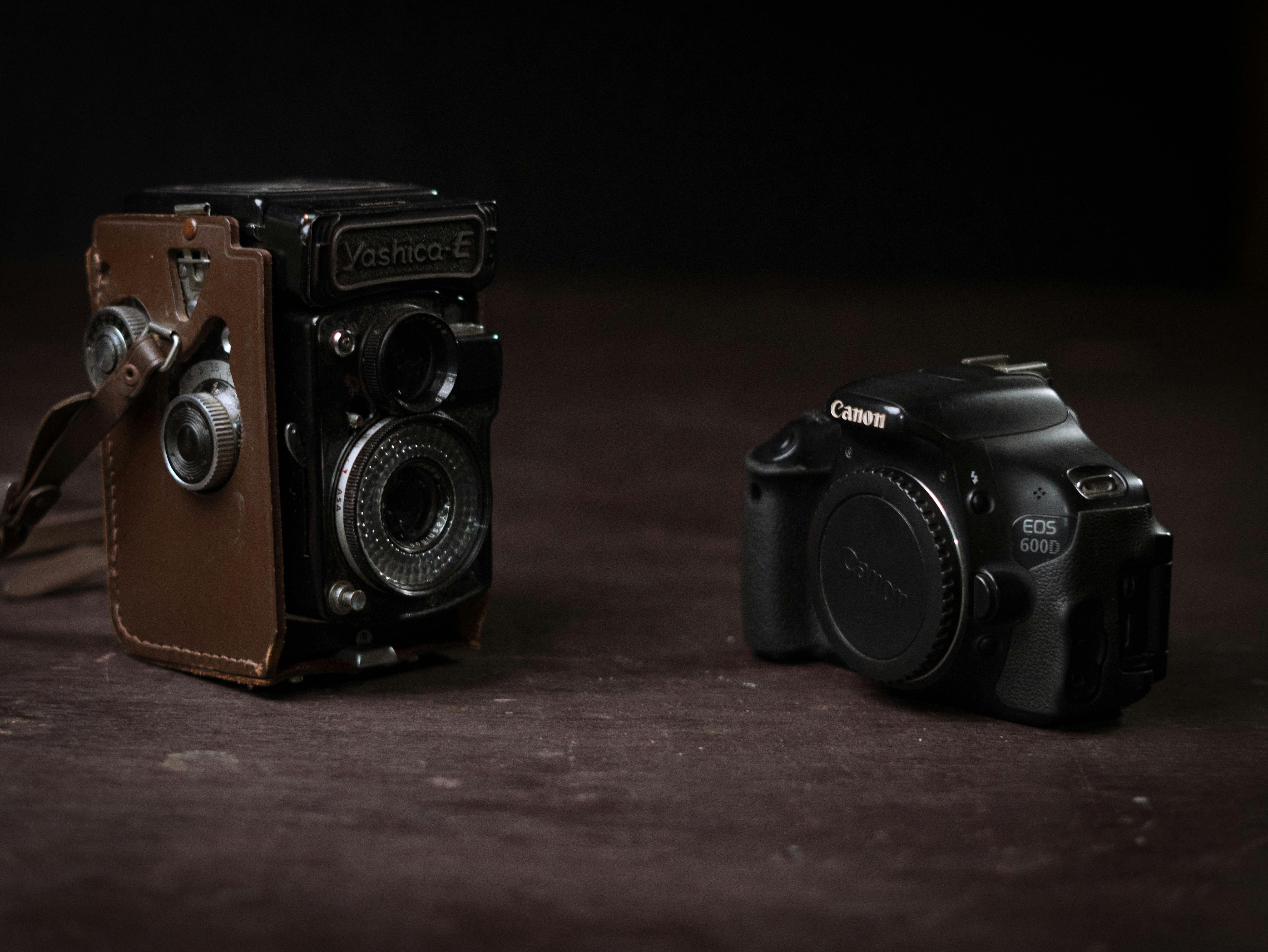 Comparison of a vintage Yashica film camera and a modern Canon DSLR, illustrating old and new photography technology.