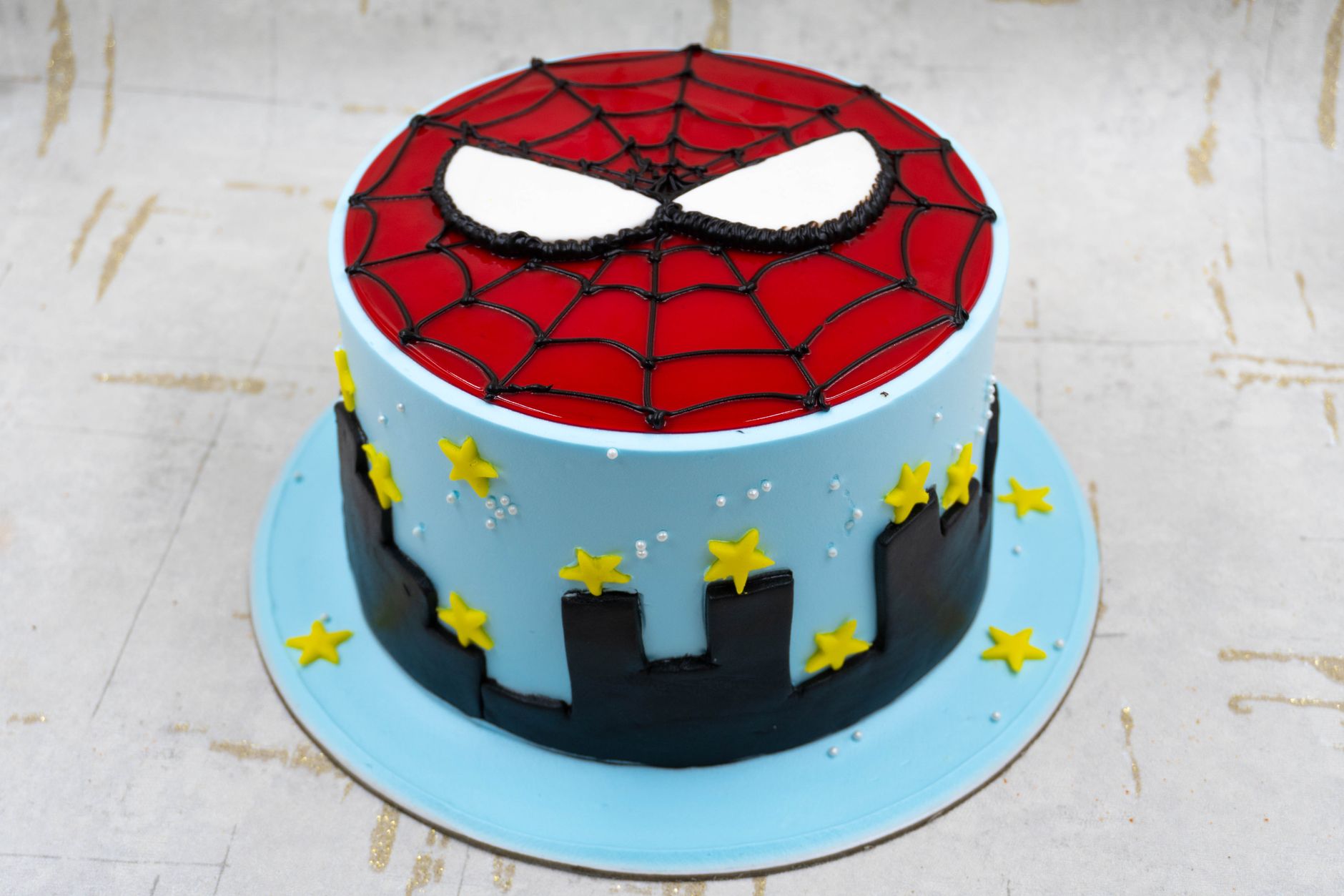 Vibrant Spider-Man themed cake featuring web design and cityscape for birthdays or events.