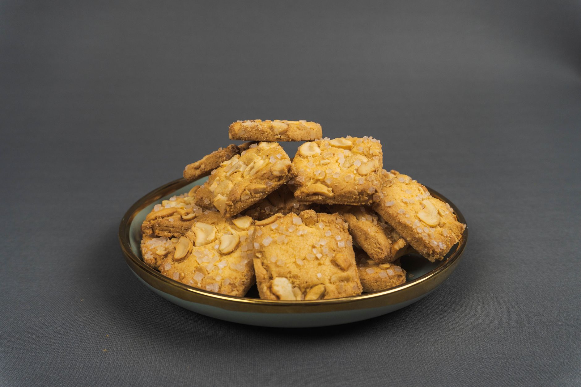 Stack of golden brown almond crisp cookies cooling on a wire rack