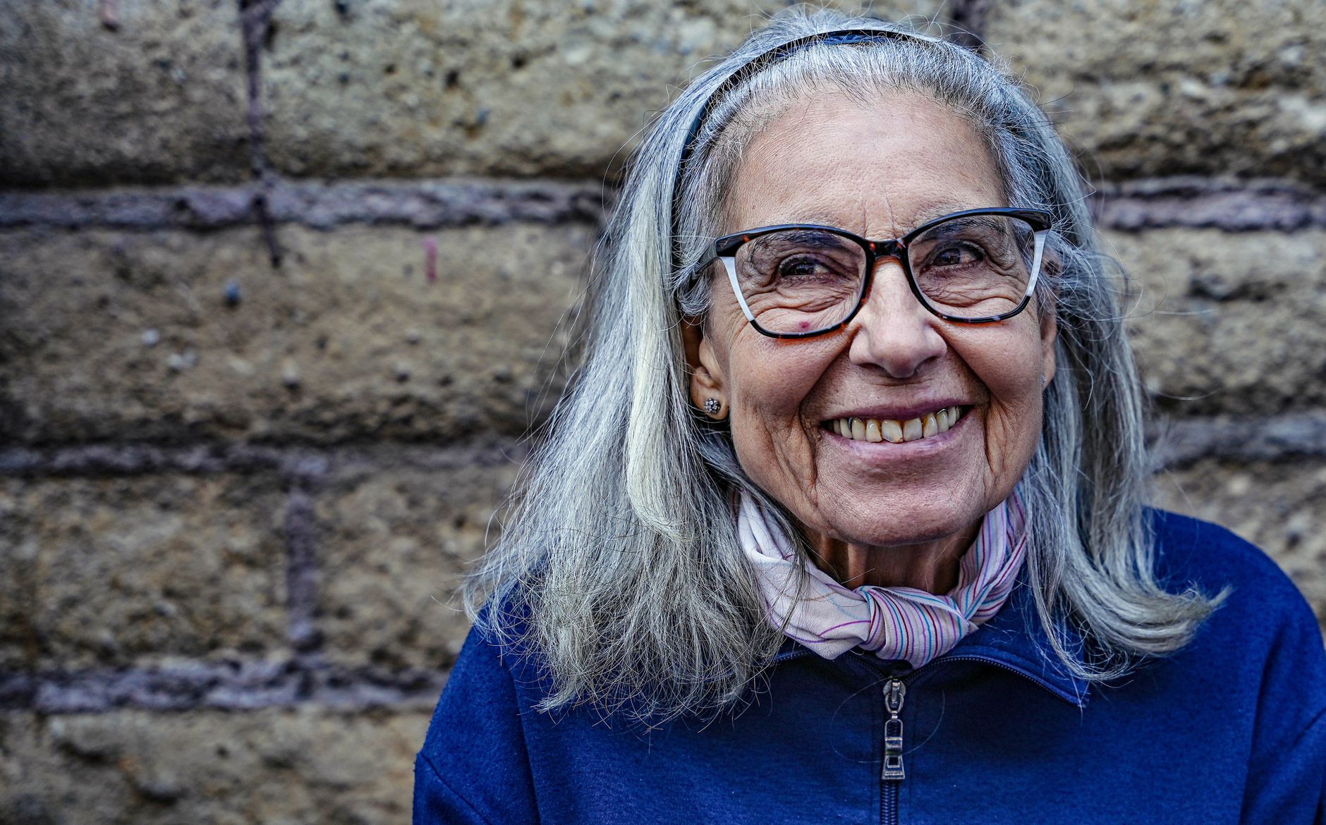 Une femme souriante profite d'une meilleure qualité de vie grâce à son appareil auditif assuré chez Europe Audition.