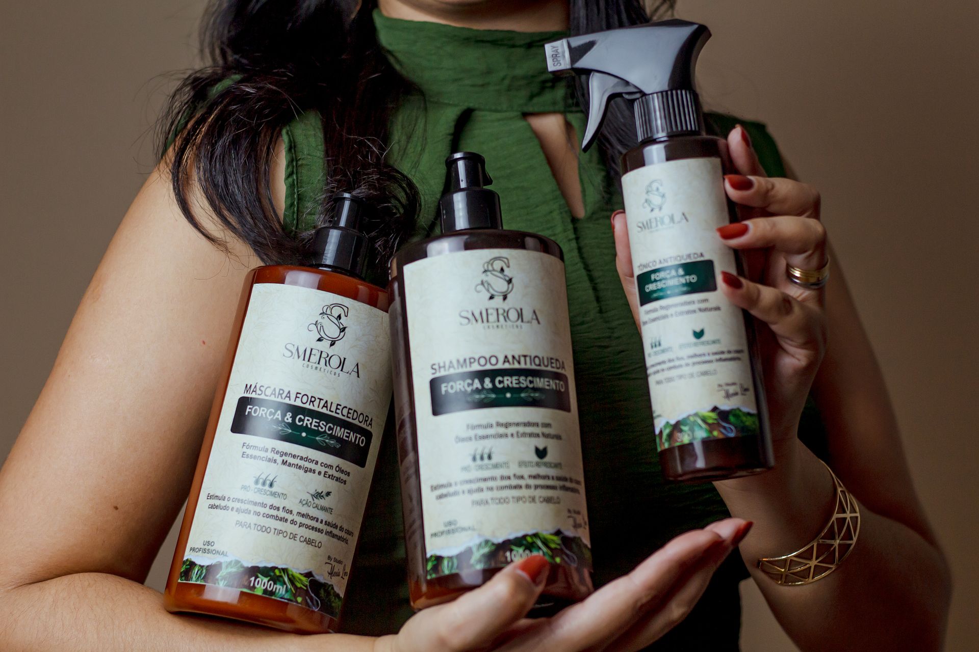 Close-up of a woman holding hair care products aimed at strengthening and stimulating hair growth.