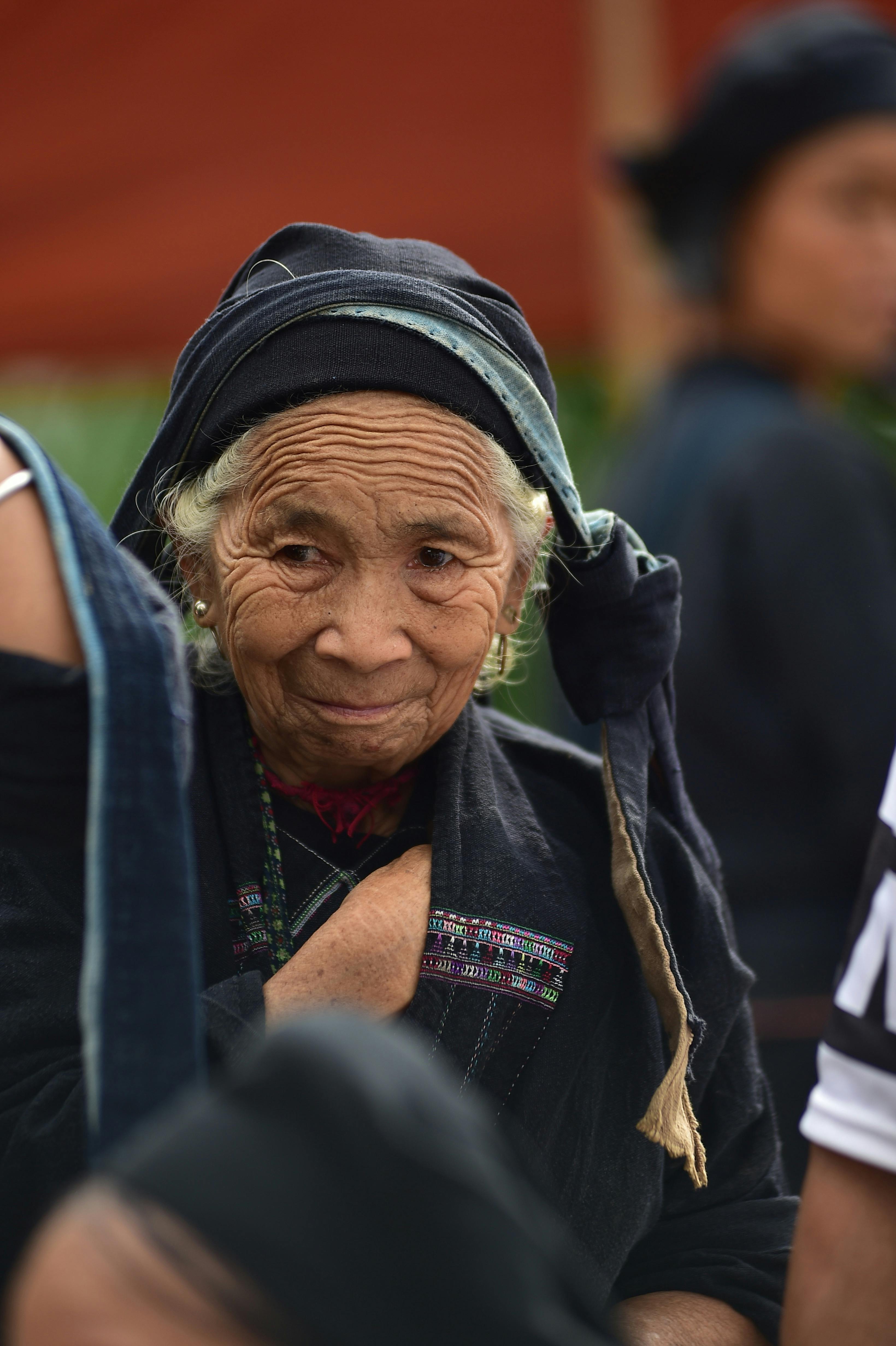 Portrait of an elderly woman wearing traditional attire with a thoughtful expression.