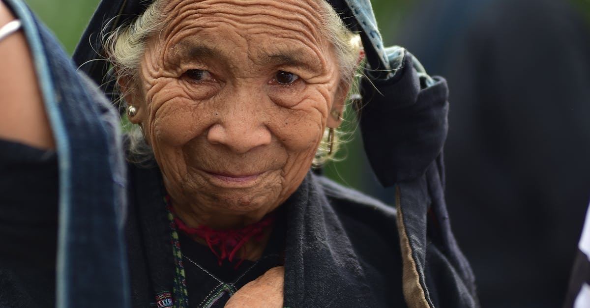 Portrait of an elderly woman wearing traditional attire with a thoughtful expression.