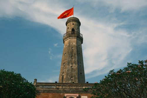 Free Historic lighthouse with Vietnam's flag in Nam Dinh against a clear sky. Stock Photo