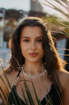 Portrait of a young woman enjoying the sunny outdoors with a tropical background.