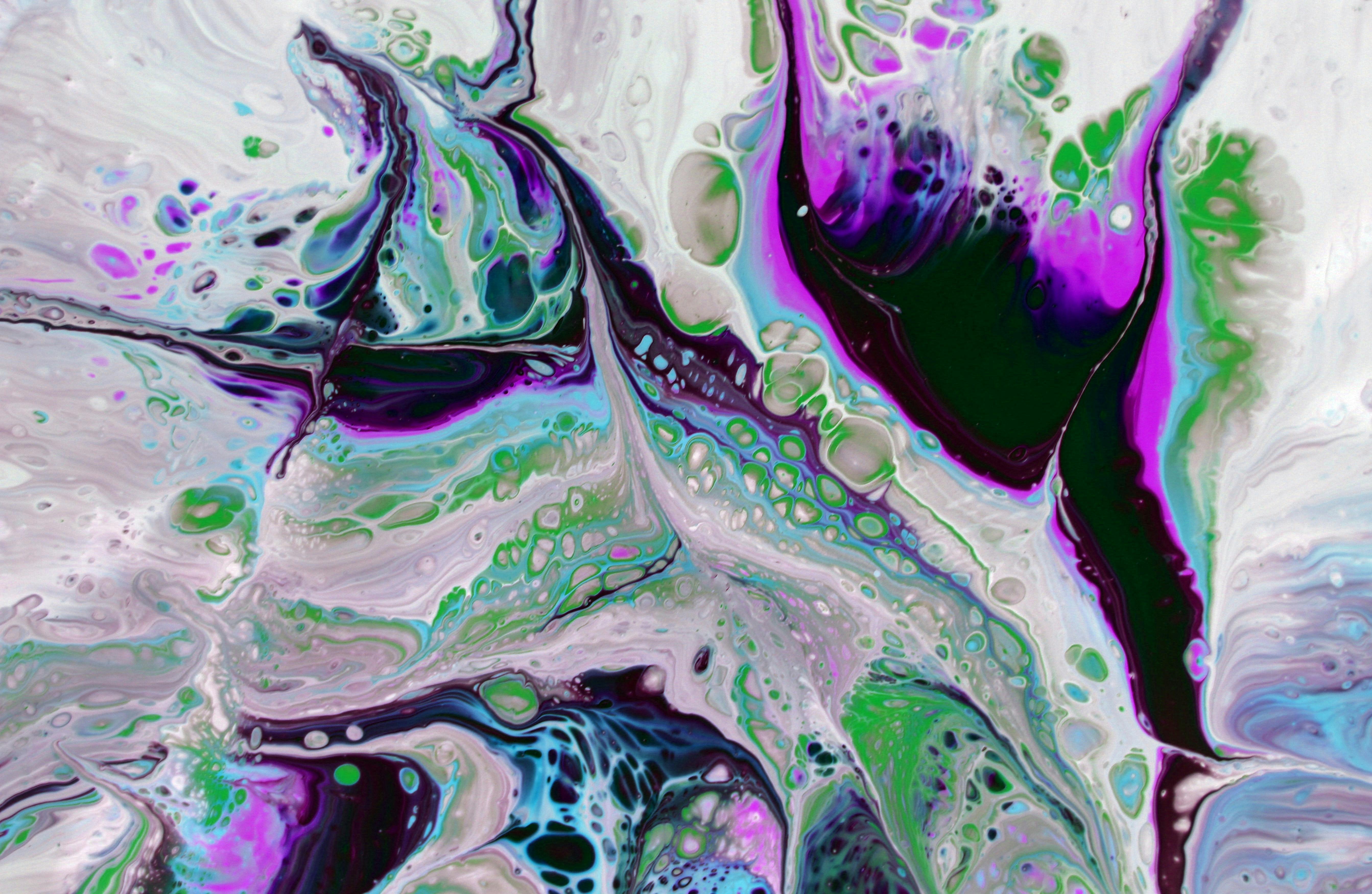Colorful abstract fluid art with swirling purple, green, and blue patterns creating vibrant textures.